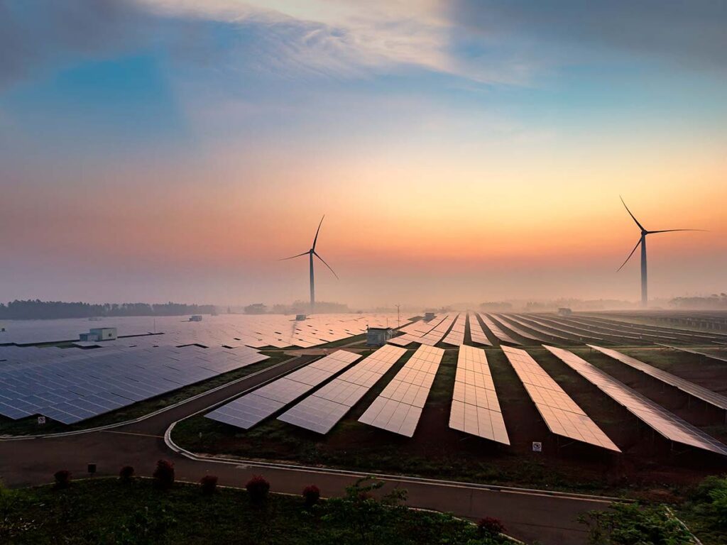 large open landscape with solar panels and wind turbines in the distance