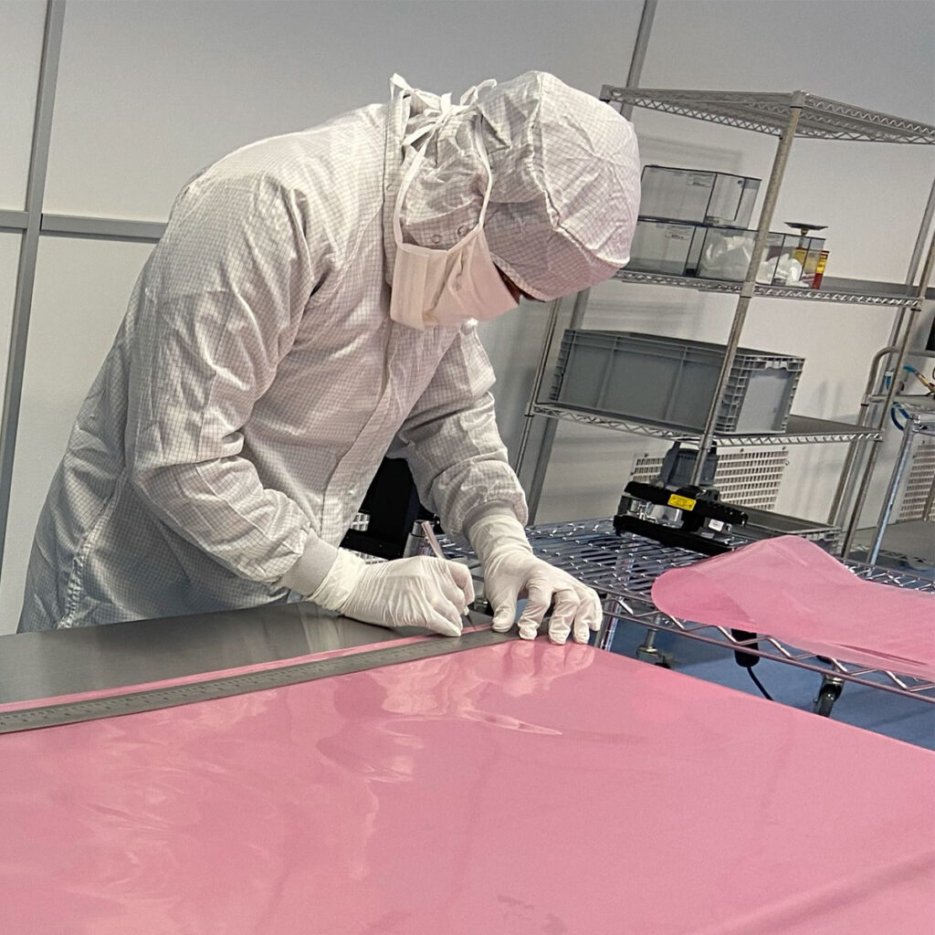 cleanroom technician measuring and cutting protective material