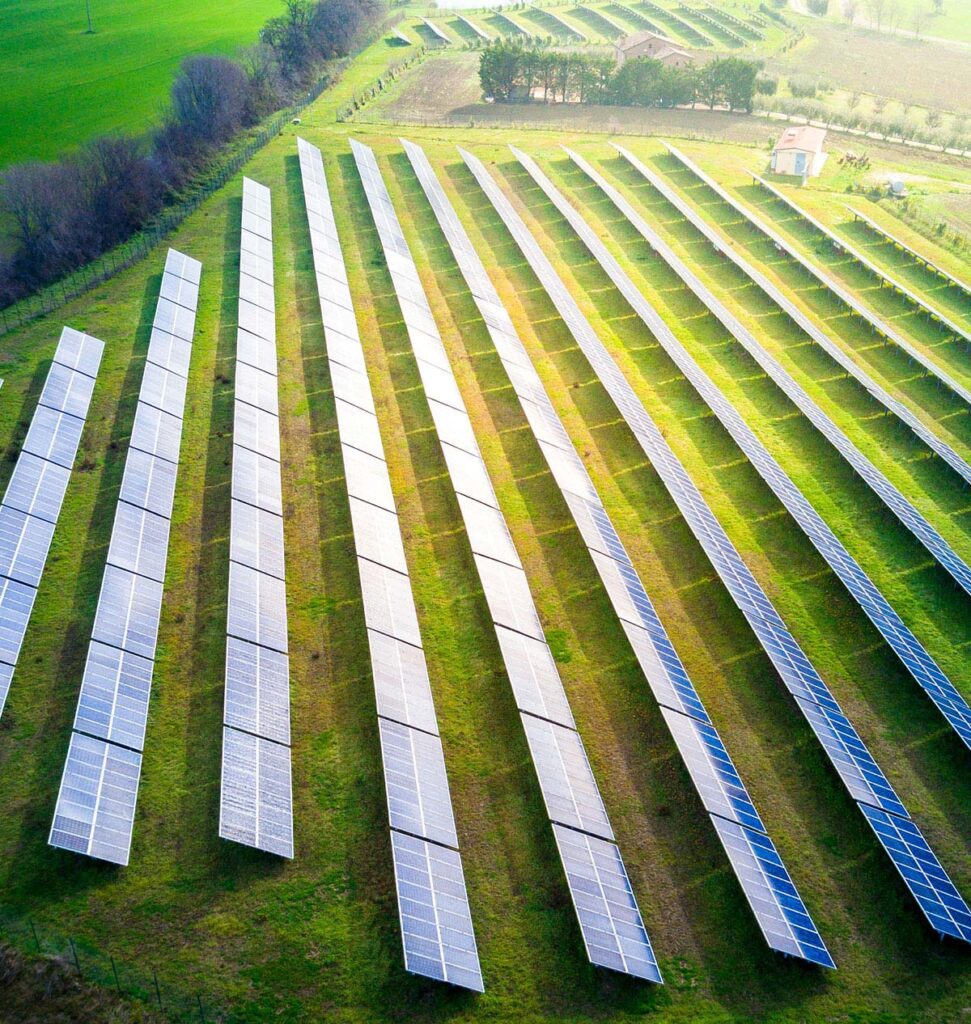 large array of solar panels in a green field